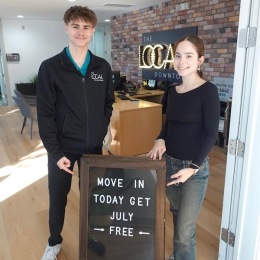 a boy and a girl standing in front of a sign