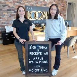 two girls standing in front of a sign